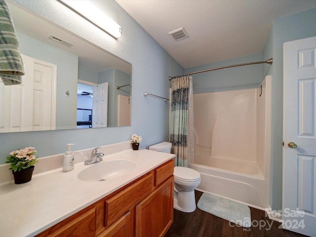 full bathroom with vanity, toilet, shower / bathtub combination with curtain, and hardwood / wood-style floors