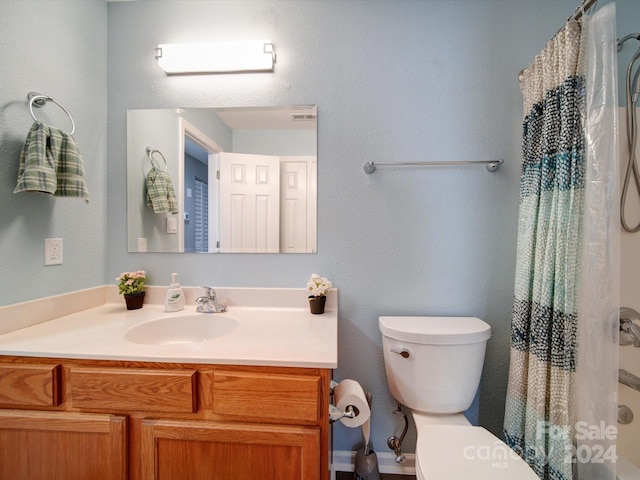 bathroom featuring vanity, toilet, and curtained shower