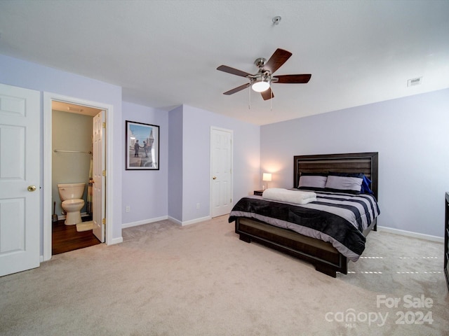 carpeted bedroom featuring a closet, ensuite bathroom, and ceiling fan