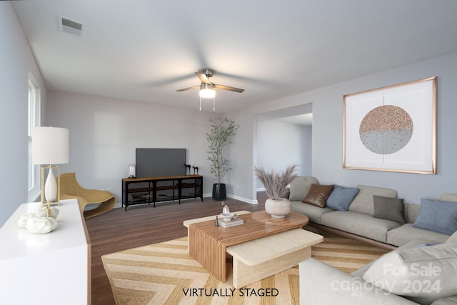 living room with dark hardwood / wood-style floors and ceiling fan