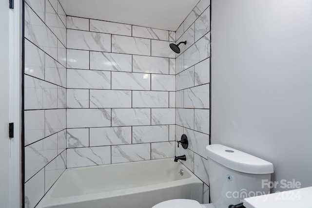 bathroom featuring tiled shower / bath combo and toilet