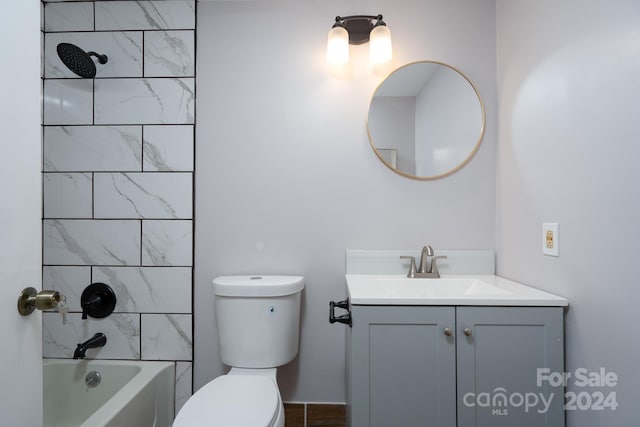 full bathroom with tiled shower / bath, vanity, and toilet