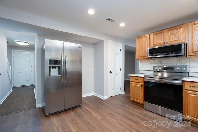 kitchen featuring appliances with stainless steel finishes, dark hardwood / wood-style floors, and backsplash