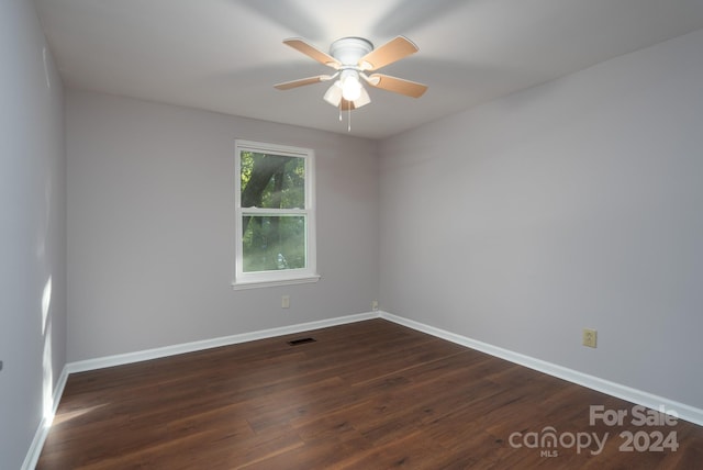 spare room with ceiling fan and dark wood-type flooring