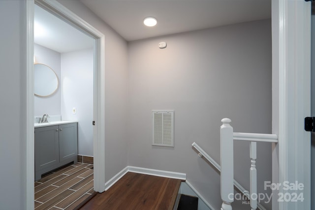 stairway with sink and hardwood / wood-style floors