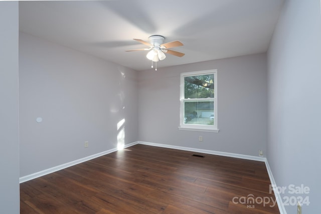 spare room featuring ceiling fan and dark wood-type flooring