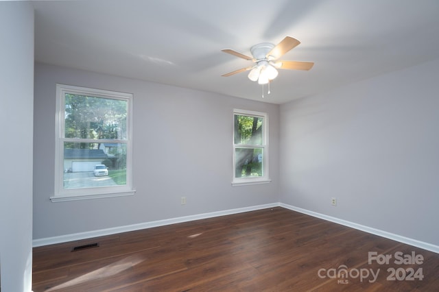 empty room with ceiling fan and dark wood-type flooring