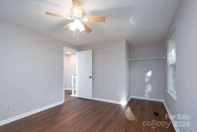 unfurnished bedroom featuring ceiling fan, a closet, and dark wood-type flooring