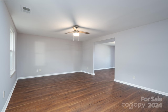 empty room with ceiling fan and dark hardwood / wood-style flooring