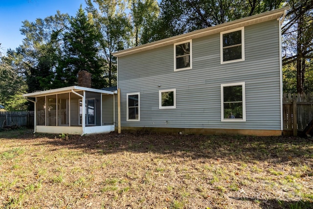 back of house featuring a yard and a sunroom