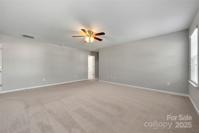 carpeted spare room featuring a wealth of natural light and ceiling fan