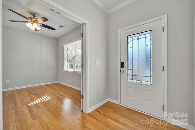 foyer with ceiling fan, ornamental molding, and light hardwood / wood-style flooring