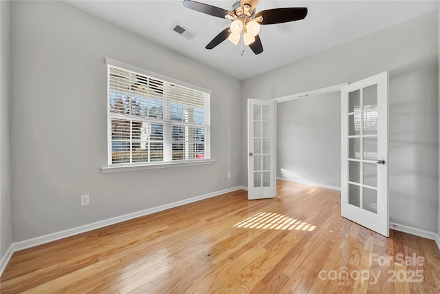 spare room featuring french doors, ceiling fan, and light wood-type flooring