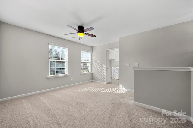 spare room featuring light carpet and ceiling fan