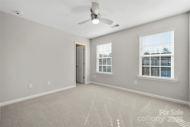 carpeted empty room featuring ceiling fan