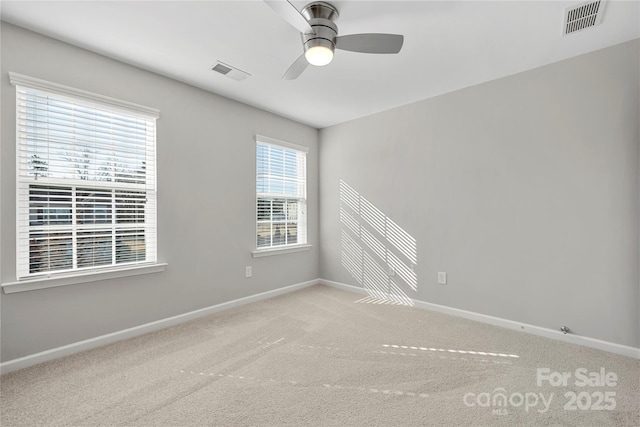 spare room featuring a healthy amount of sunlight, light carpet, and ceiling fan