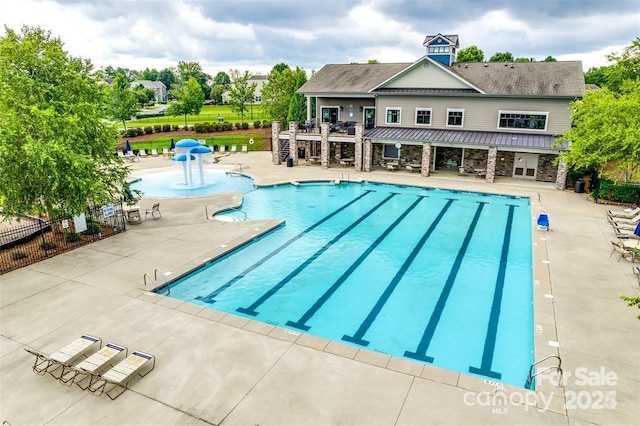 view of pool with pool water feature and a patio area