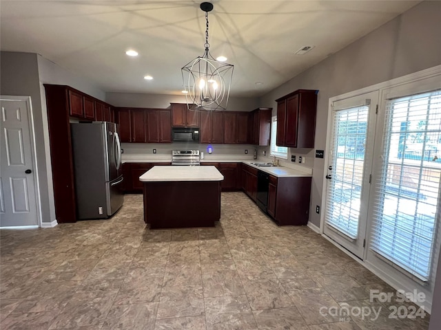 kitchen with sink, black appliances, a center island, pendant lighting, and an inviting chandelier