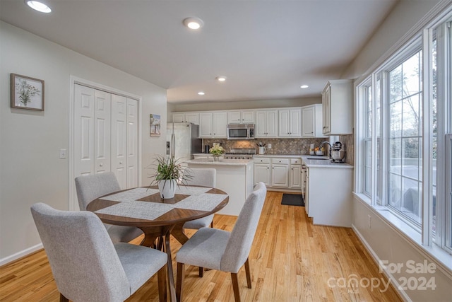 dining room featuring sink and light hardwood / wood-style floors