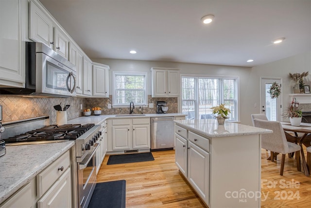 kitchen with sink, white cabinetry, backsplash, and appliances with stainless steel finishes