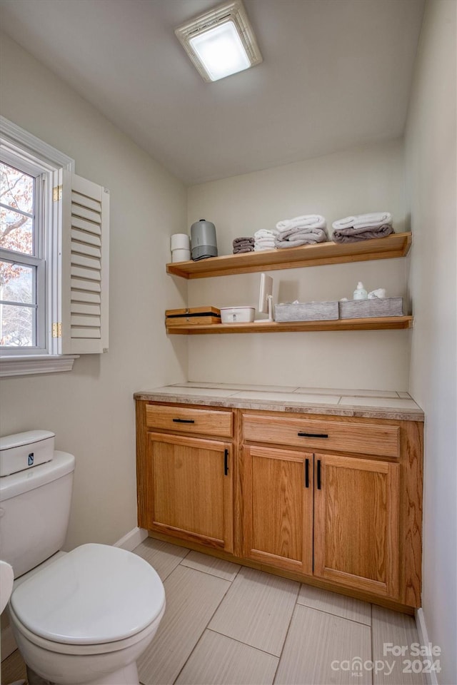 bathroom featuring tile patterned floors, vanity, and toilet