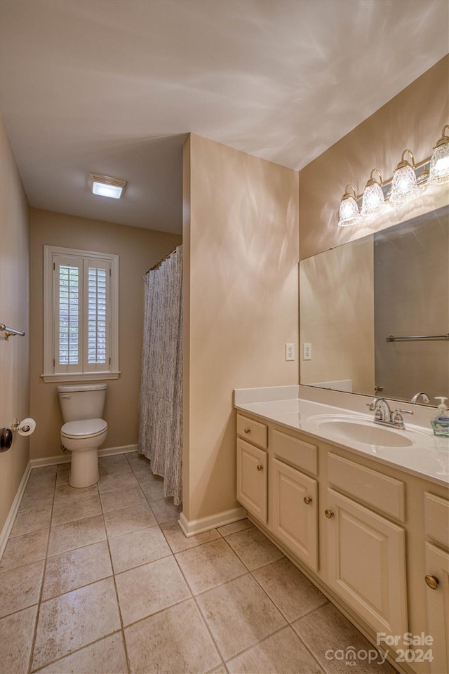 bathroom with tile patterned floors, vanity, and toilet