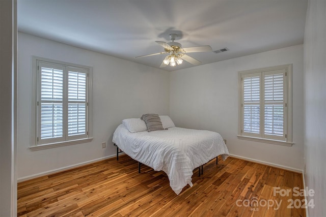 bedroom with ceiling fan and hardwood / wood-style flooring