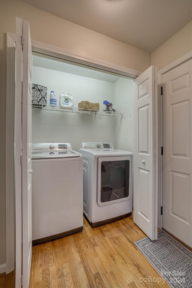 laundry room with light hardwood / wood-style floors and independent washer and dryer