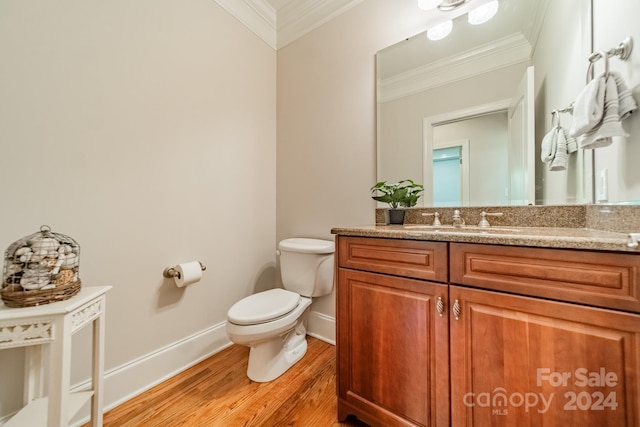 bathroom featuring vanity, toilet, hardwood / wood-style flooring, and ornamental molding