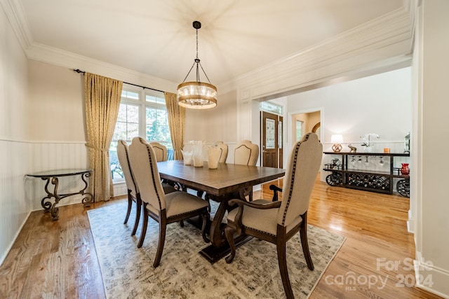 dining room featuring ornamental molding, a notable chandelier, and hardwood / wood-style flooring