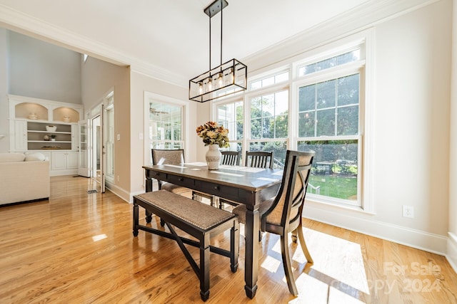 dining room featuring light hardwood / wood-style floors, crown molding, and an inviting chandelier