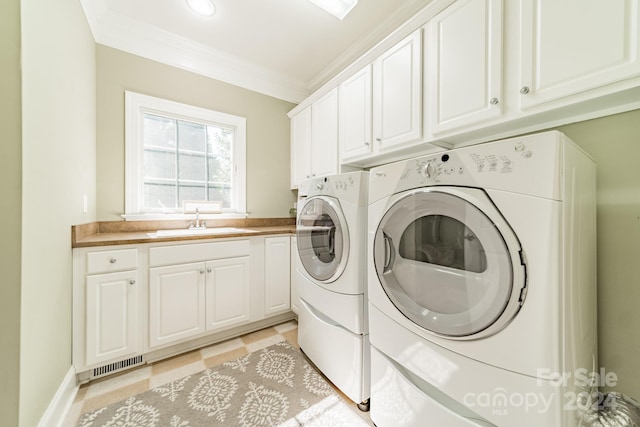 laundry area featuring sink, crown molding, separate washer and dryer, light tile patterned floors, and cabinets