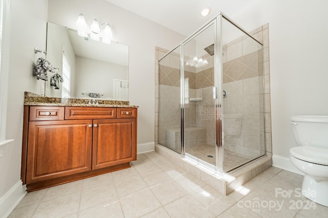 bathroom featuring vanity, toilet, tile patterned floors, and a shower with shower door