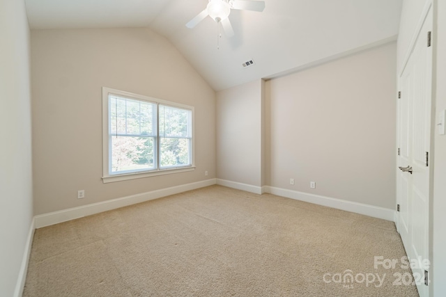 carpeted empty room with ceiling fan and vaulted ceiling