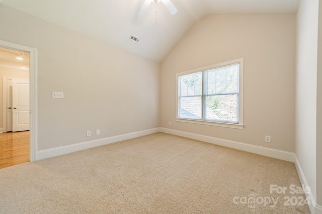 carpeted empty room featuring ceiling fan and lofted ceiling