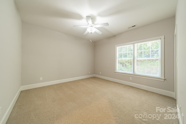 carpeted spare room featuring ceiling fan