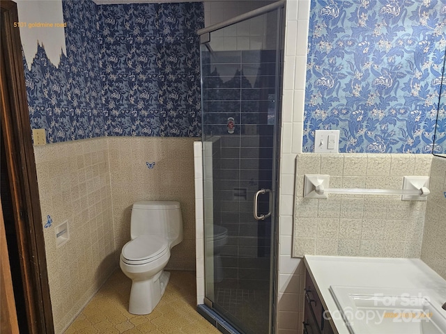 bathroom featuring vanity, toilet, tile walls, and an enclosed shower