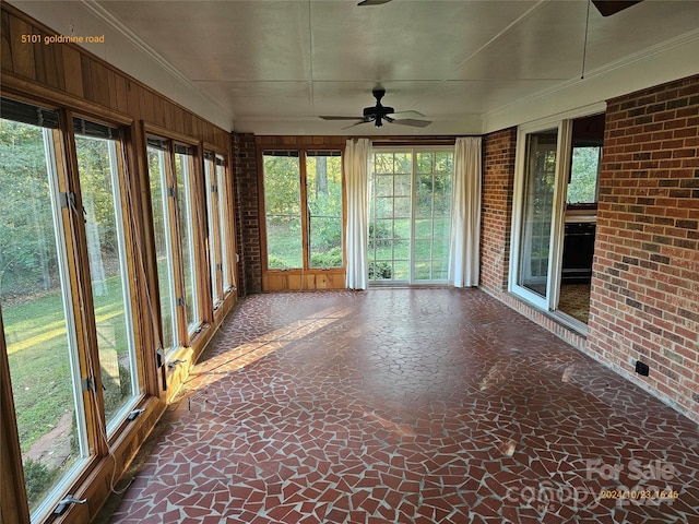 unfurnished sunroom with ceiling fan