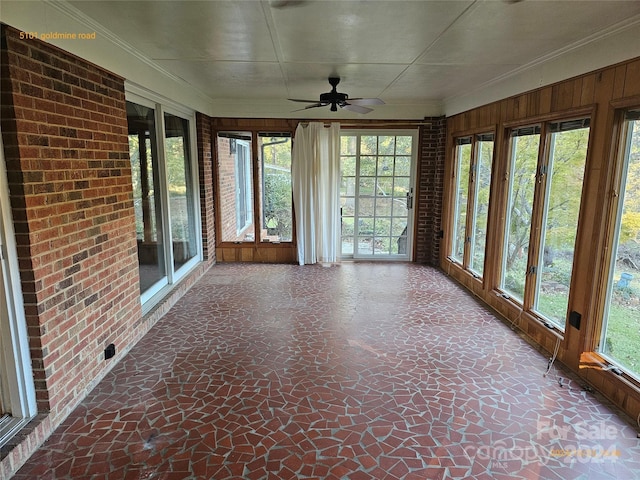 unfurnished sunroom featuring ceiling fan