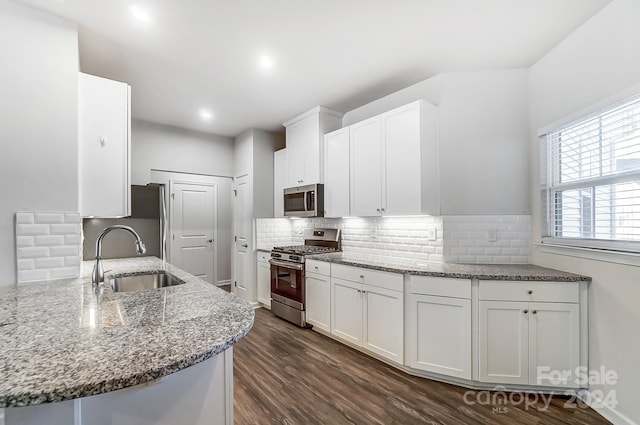 kitchen featuring sink, stainless steel appliances, dark hardwood / wood-style flooring, kitchen peninsula, and white cabinets