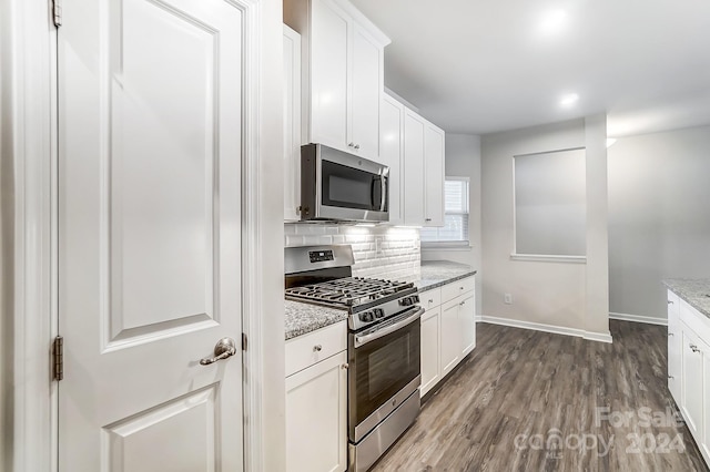 kitchen featuring light stone countertops, backsplash, stainless steel appliances, hardwood / wood-style flooring, and white cabinets