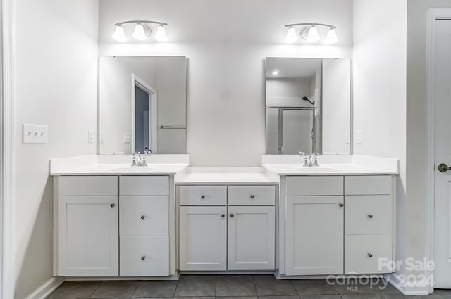 bathroom featuring tile patterned flooring, vanity, and walk in shower