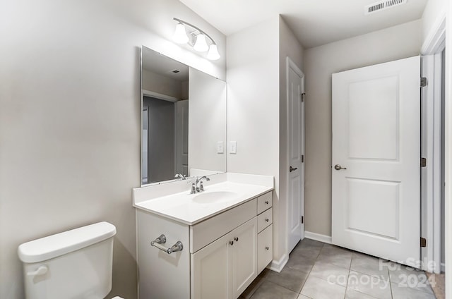 bathroom featuring tile patterned flooring, vanity, and toilet