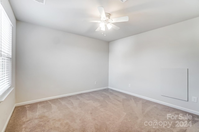 carpeted spare room featuring ceiling fan