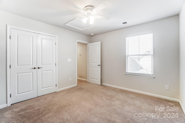 unfurnished bedroom featuring ceiling fan, a closet, and light colored carpet