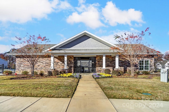 craftsman-style home with covered porch and a front yard