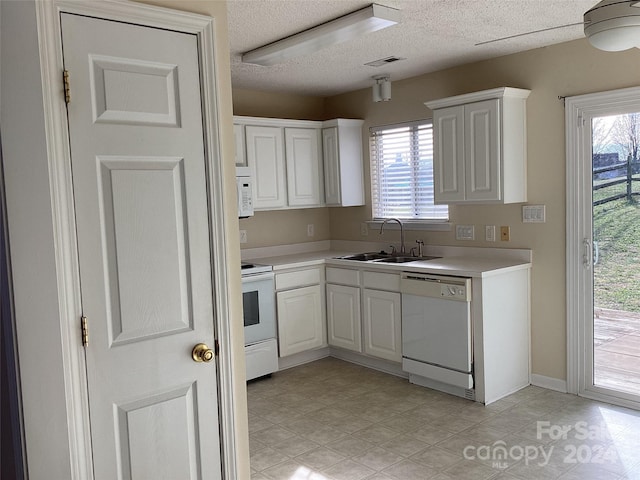 kitchen with white cabinets, white appliances, and sink