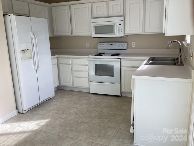 kitchen featuring white cabinetry, sink, and white appliances