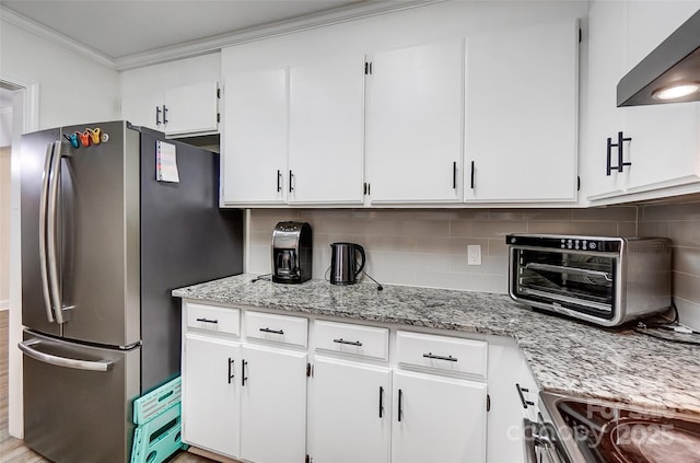 kitchen with decorative backsplash, stainless steel appliances, ornamental molding, white cabinets, and wall chimney exhaust hood