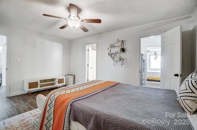 bedroom featuring ceiling fan, a textured ceiling, dark hardwood / wood-style flooring, and ensuite bath